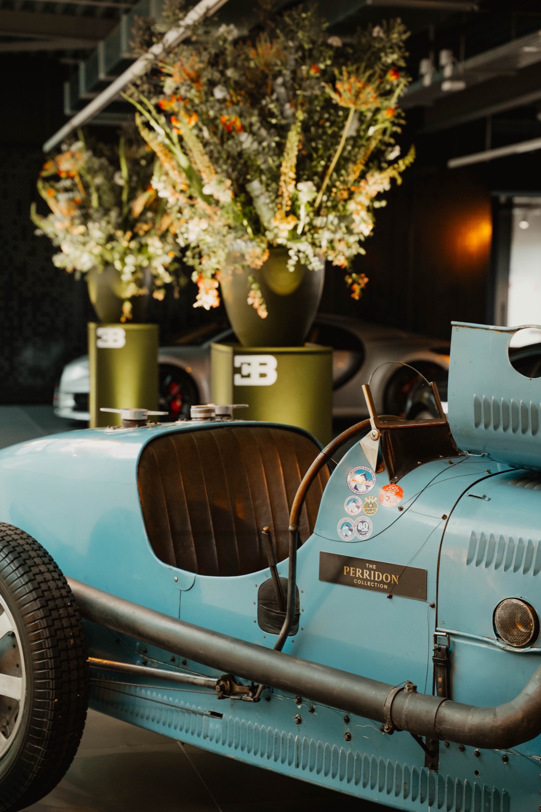 Klassieke Bugatti raceauto tussen bloemstukken